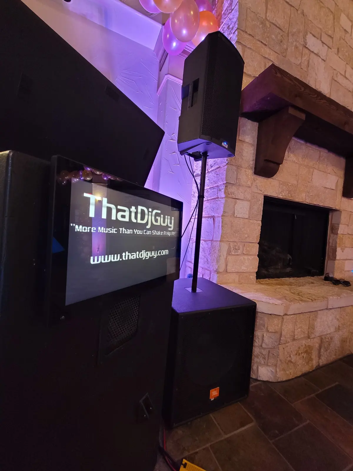 The illuminated ThatDjGuy equipment rack and speaker system at a private event